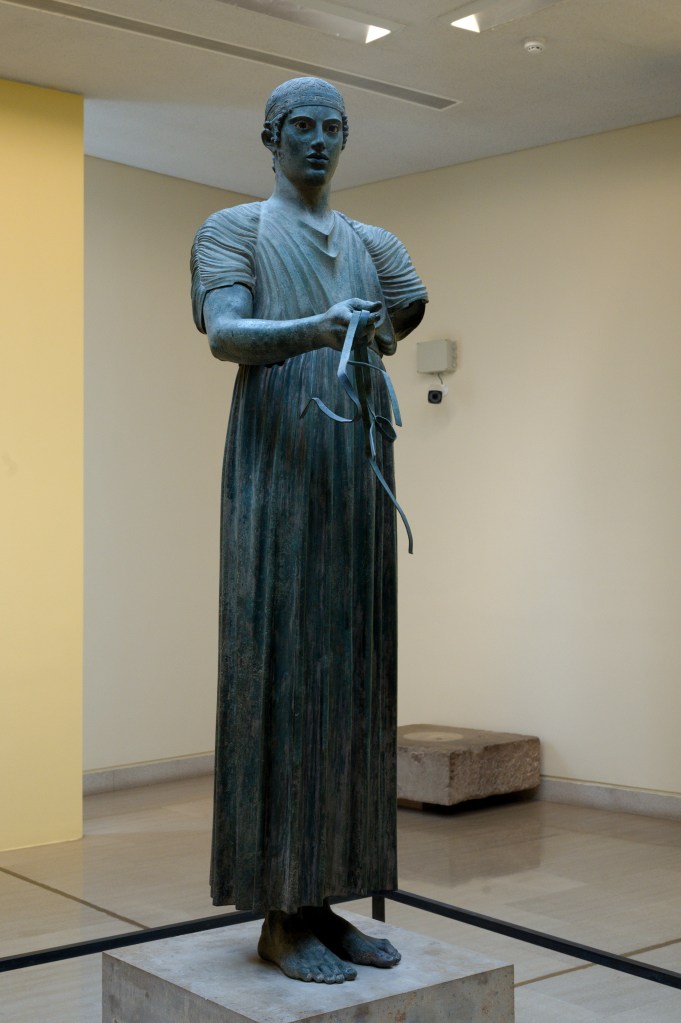 Bronze statue of the Delphi Charioteer displayed at the Archaeological Museum of Delphi.