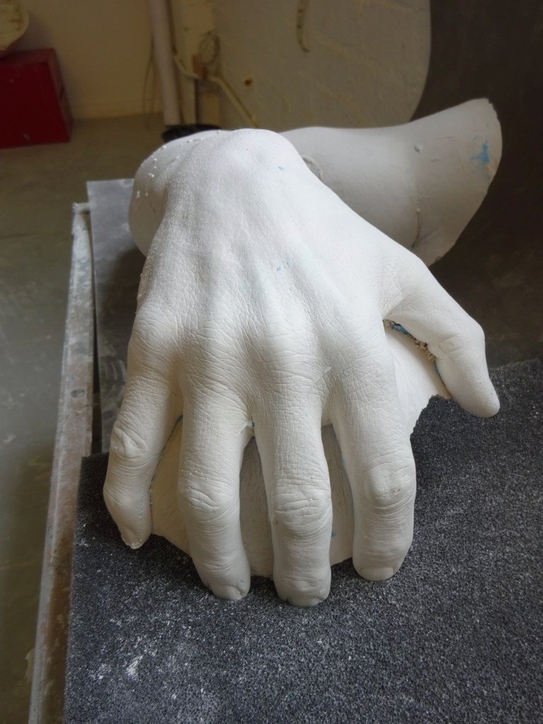 Life cast of a hand, executed in white plaster, made using alginate.