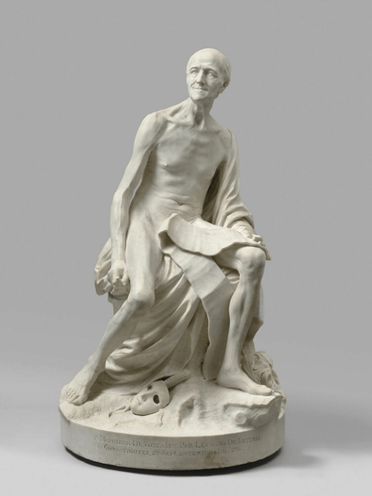 A nude sculpture of Voltaire in white marble. 